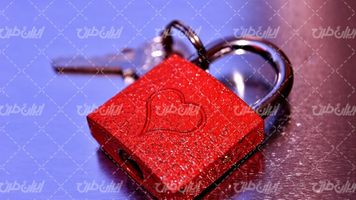 تصویر با کیفیت قفل قرمز رنگ همراه با کلید و قلب