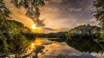 تصویر با کیفیت چشم انداز زیبای غروب آفتاب همراه با منظره دریاچه و جنگل