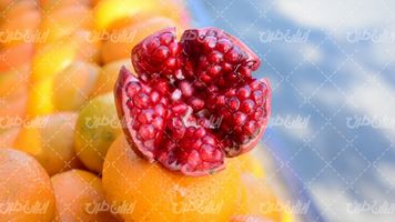 تصویر با کیفیت انار همراه با میوه و آب میوه و آب پرتقال