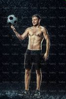 تمرین با توپ فوتبالیست ورزش زیر باران قطرات آب