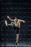 تمرین با توپ فوتبالیست ورزش زیر باران قطرات آب7