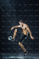 تمرین با توپ فوتبالیست ورزش زیر باران قطرات آب9