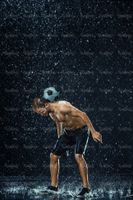 تمرین با توپ فوتبالیست ورزش زیر باران قطرات آب10