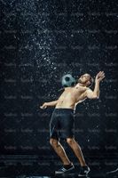 تمرین با توپ فوتبالیست ورزش زیر باران قطرات آب13