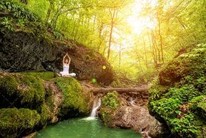 ورزش یوگا در بالای آبشار رودخانه منظره