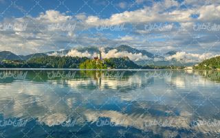 تصویر با کیفیت دریاچه زیبا و چشم انداز کوه ،جنگل و آسمان نیمه ابری