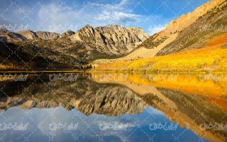 تصویر با کیفیت دریاچه به همراه آسمان آبی و کوه ، پوشش گیاهی