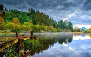 تصویر با کیفیت منظره زیبای دریاچه به همراه درخت و ابر سیاه
