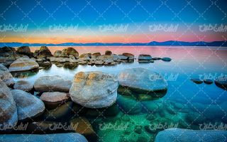 تصویر با کیفیت منظره دریاچه همراه با آسمان آبی و صخره