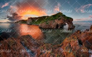 تصویر با کیفیت منظره غروب آفتاب همراه با صخره و دریا