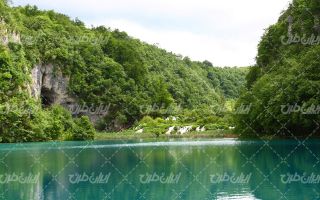 تصویر با کیفیت دریاچه به همراه آسمان آبی و جنگل انبوه
