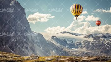 تصویر با کیفیت منظره زیبای پرواز بالون همراه با کوهستان و کلبه چوبی
