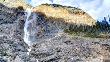 تصویر با کیفیت آبشار همراه با چشم انداز زیبایی طبیعت و کوه