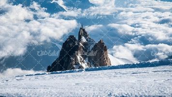 تصویر با کیفیت کوه همراه با منظره دیدنی زمستان و ابرهای سفید