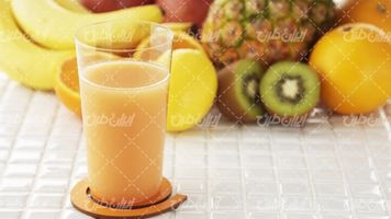 تصویر با کیفیت آب میوه همراه با دسته کیوی و آبمیوه طبیعی