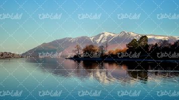 تصویر با کیفیت دریاچه همراه با کوه چشم انداز زیبای آسمان آبی