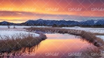 تصویر با کیفیت چشم انداز زیبای غروب آفتاب همراه با فصل زمستان و رودخانه