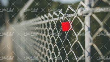 تصویر با کیفیت فنس همراه با قفل قرمز رنگ و حصار فلزی