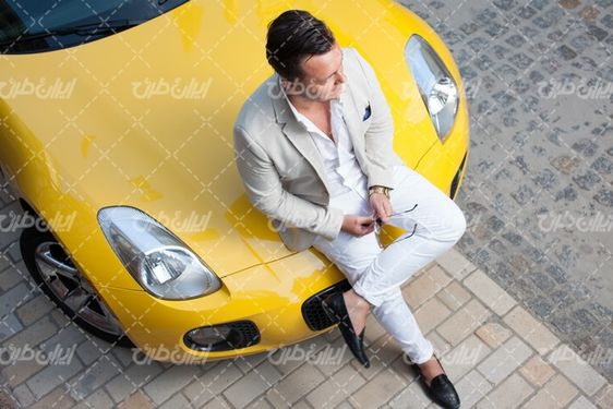 تصویر با کیفیت اتومبیل زرد رنگ همراه با خودرو اسپرت و نمایشگاه خودرو