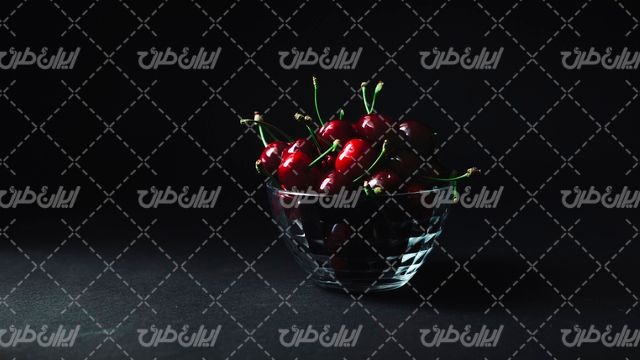 تصویر با کیفیت میوه همراه با ظرف شیشه ای میوه و گیلاس