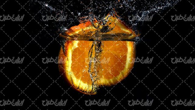 تصویر با کیفیت پرتقال همراه با آب میوه طبیعی و آب زلال