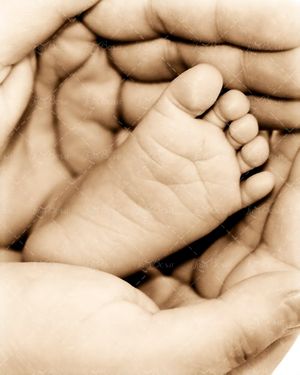 پاهای نوزاد در دستان مادر بچه 