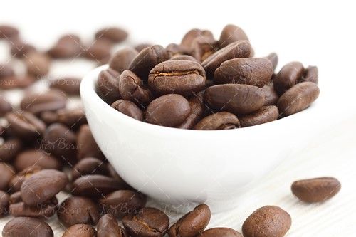 دانه های قهوه داخل فنجان سفید 
