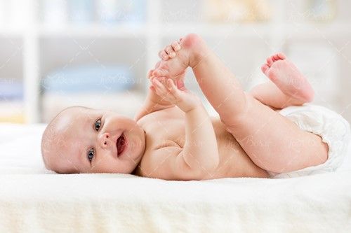 کودک در حال بازی کردن با پاهای خود 