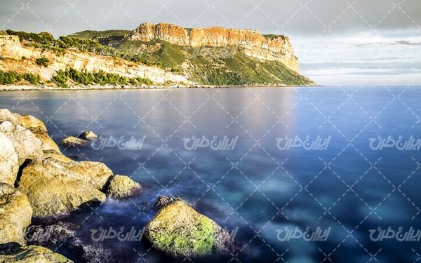 تصویر با کیفیت منظره ساحل زیبای دریا به همراه کوه عظیم