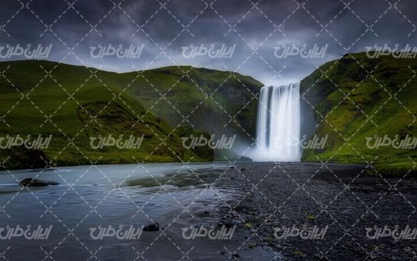 تصویر با کیفیت منظره زیبای آبشار به همراه ابرهای سیاه