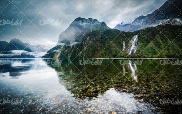 تصویر با کیفیت منظره دریاچه همراه با کوه و آسمان آبی