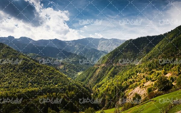 تصویر با کیفیت منظره دره همراه با کوه و آسمان آبی