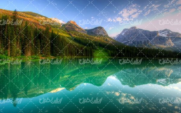 تصویر با کیفیت دریاچه به همراه کوه سنگی و آسمان آبی