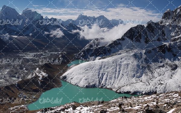 تصویر با کیفیت دریاچه زیبا به همراه کوه سنگی و آسمان آبی