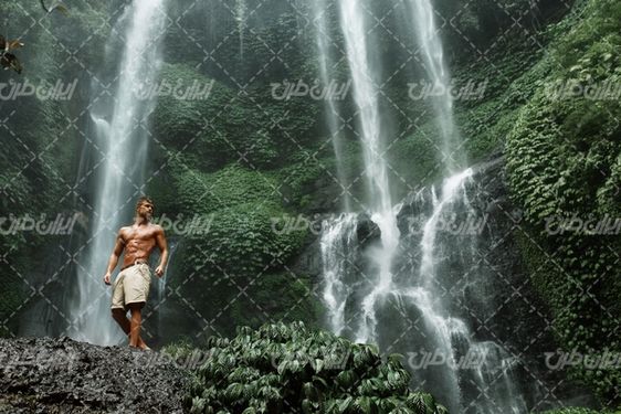 تصویر با کیفیت تناسب اندام مرد ورزشکار همراه با مرد و آبشار زیبا