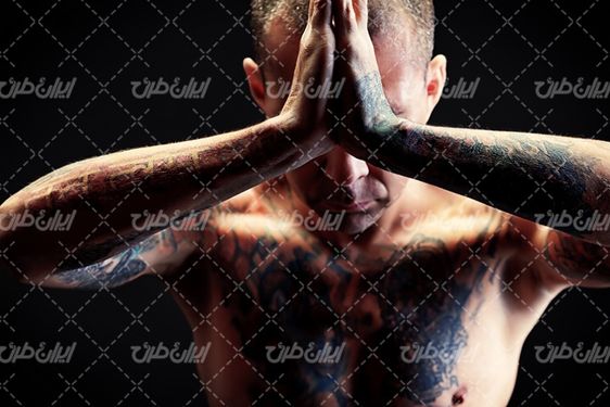 تصویر با کیفیت  مرد ورزشکار همراه با خالکوبی روی بدن و آمادگی جسمانی