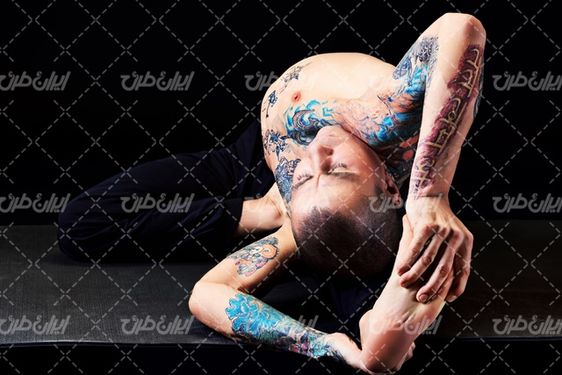 تصویر با کیفیت  مرد ورزشکار همراه با خالکوبی روی بدن و آمادگی جسمانی