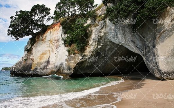تصویر با کیفیت منظره غار همراه با چشم انداز زیبایی طبیعت و دریا
