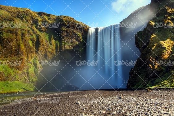 تصویر با کیفیت آبشار همراه با چشم انداز زیبایی طبیعت و صخره