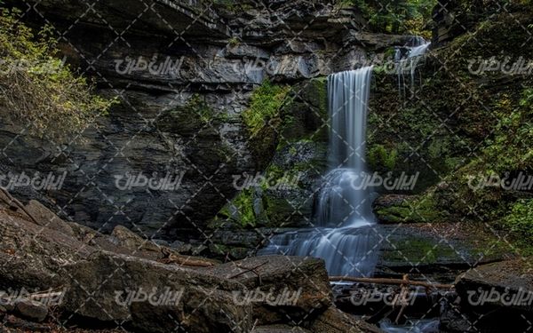 تصویر با کیفیت آبشار همراه با چشم انداز زیبایی طبیعت و صخره