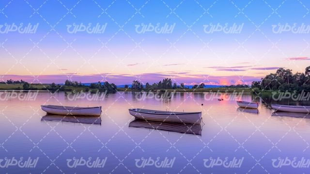 تصویر با کیفیت قایق همراه با دریاچه و منظره غروب آفتاب