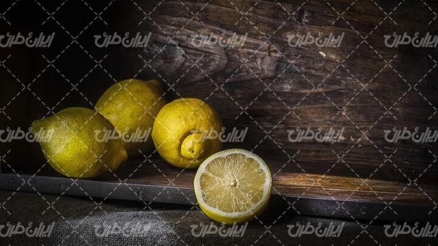 تصویر با کیفیت لیمو همراه با میوه و سطح چوبی