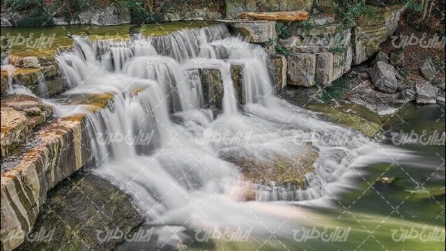 تصویر با کیفیت آبشار همراه با منظره زیبای رودخانه و طبیعت
