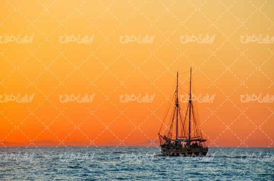 تصویر با کیفیت کشتی همراه با دریا و غروب آفتاب