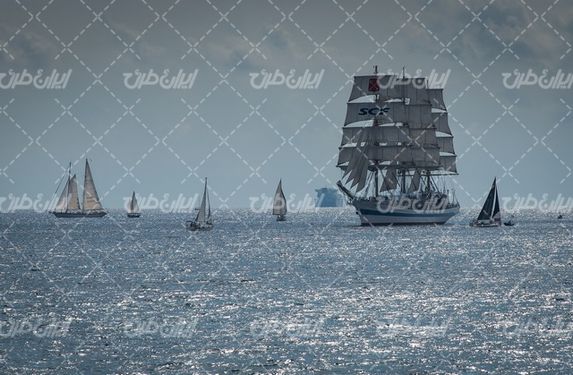 تصویر با کیفیت کشتی بادبانی همراه با قایق و منظره دریا