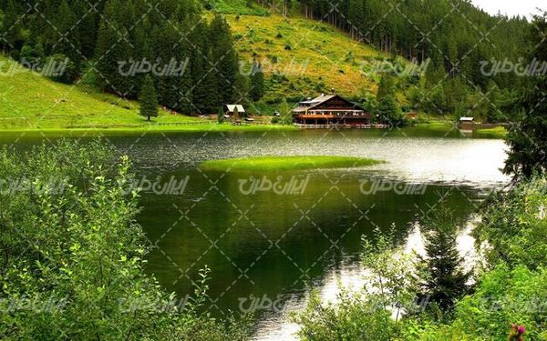 تصویر با کیفیت دریاچه همراه با چشم انداز زیبا و خانه چوبی