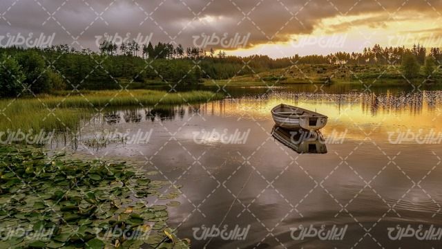 تصویر با کیفیت منظره زیبای دریاچه همراه با قایق چوبی و غروب آفتاب
