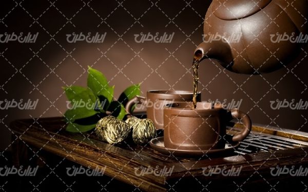 تصویر با کیفیت قوری چای همراه با فنجان چای و دمنوش