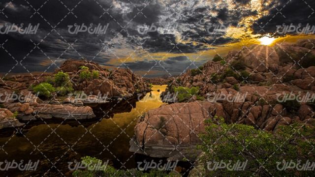 تصویر با کیفیت رودخانه همراه با منظره زیبای غروب آفتاب و صخره